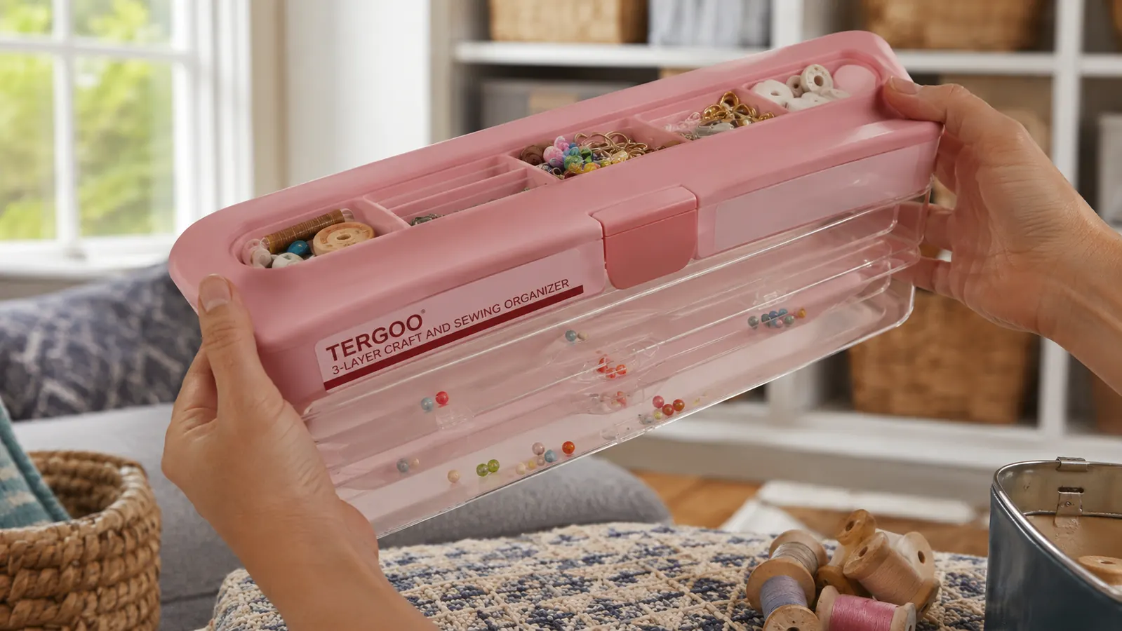Hand tilting the open TERGOO organizer to show how small beads shift between the shallow top-tray compartments